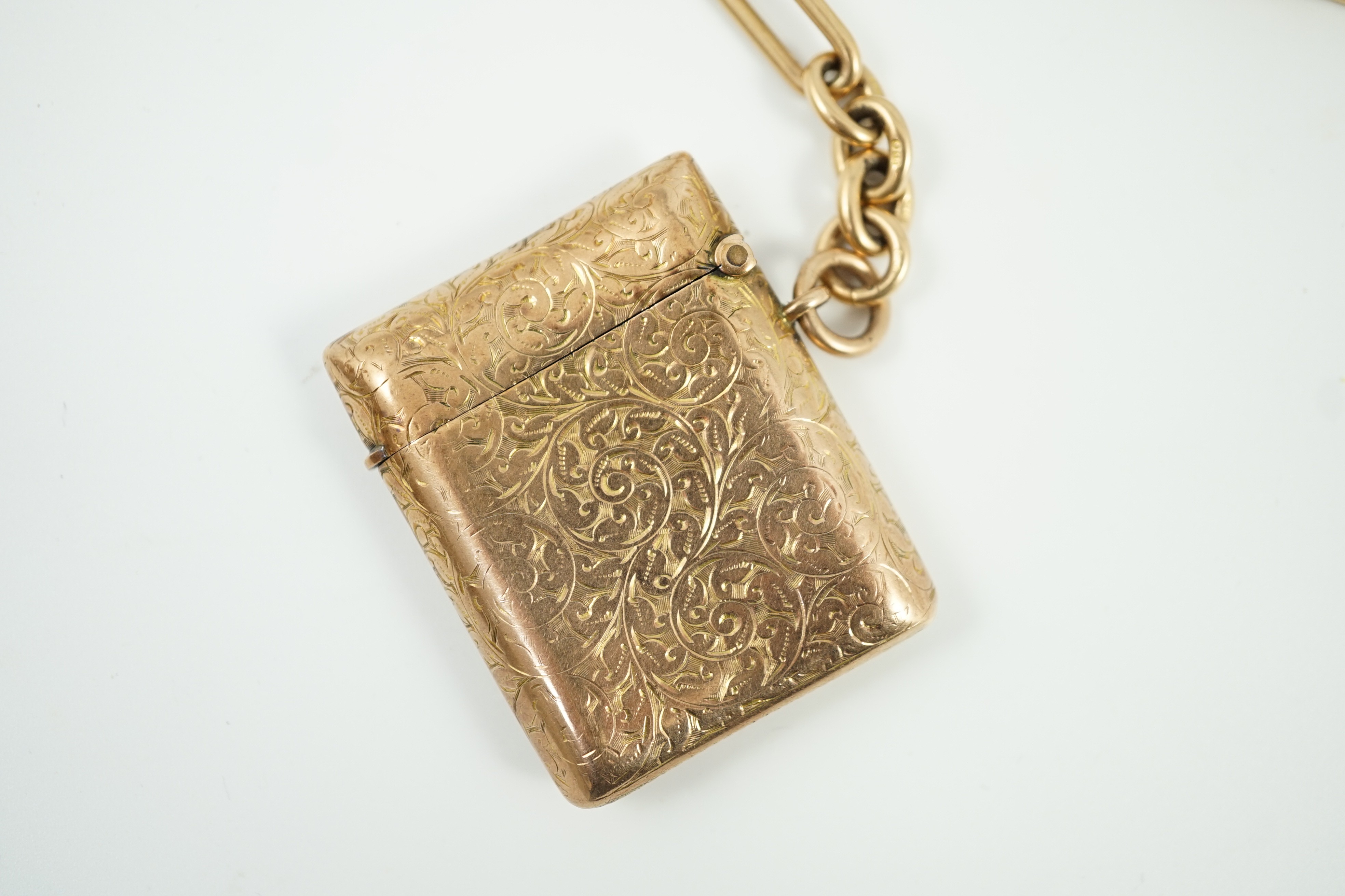 An Edwardian engraved 9ct gold vesta case, 44mm, gross 20.6 grams, together with an 18ct gold albert, 34cm, 45.8 grams.